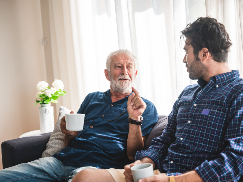 Two men sitting together and talking.