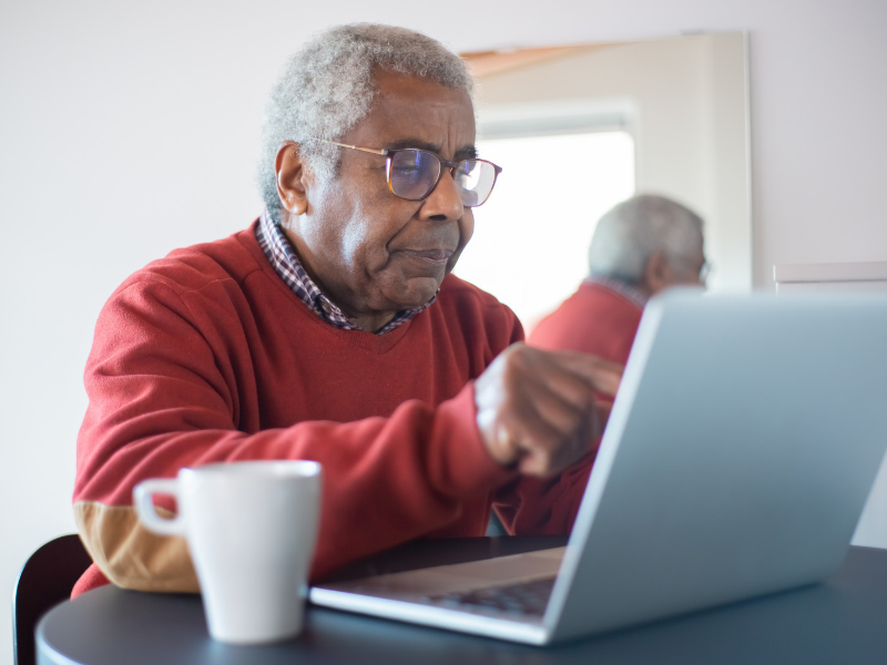An older man using a laptop to look for information and support.