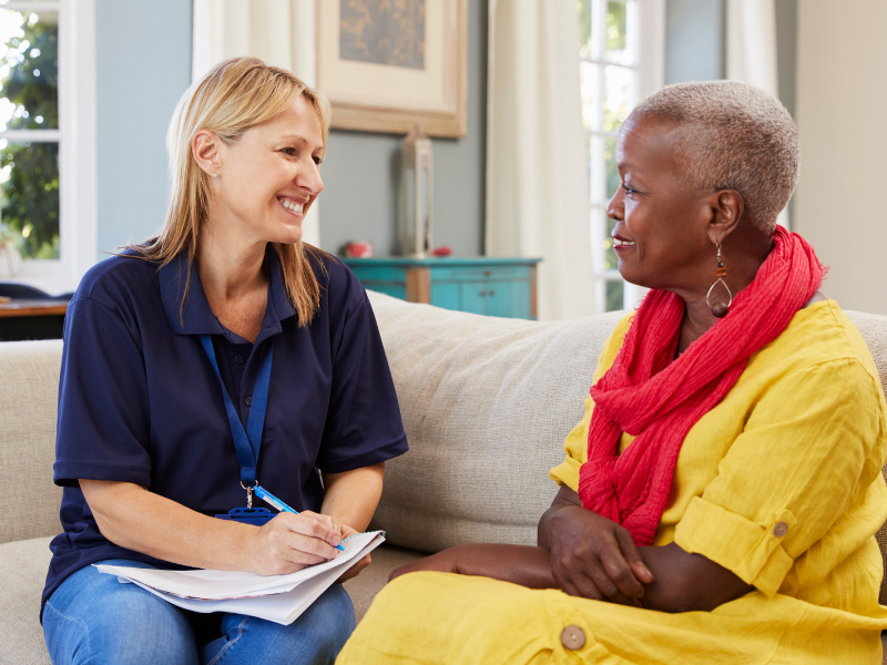 A woman talking with a support worker who is listening to her.